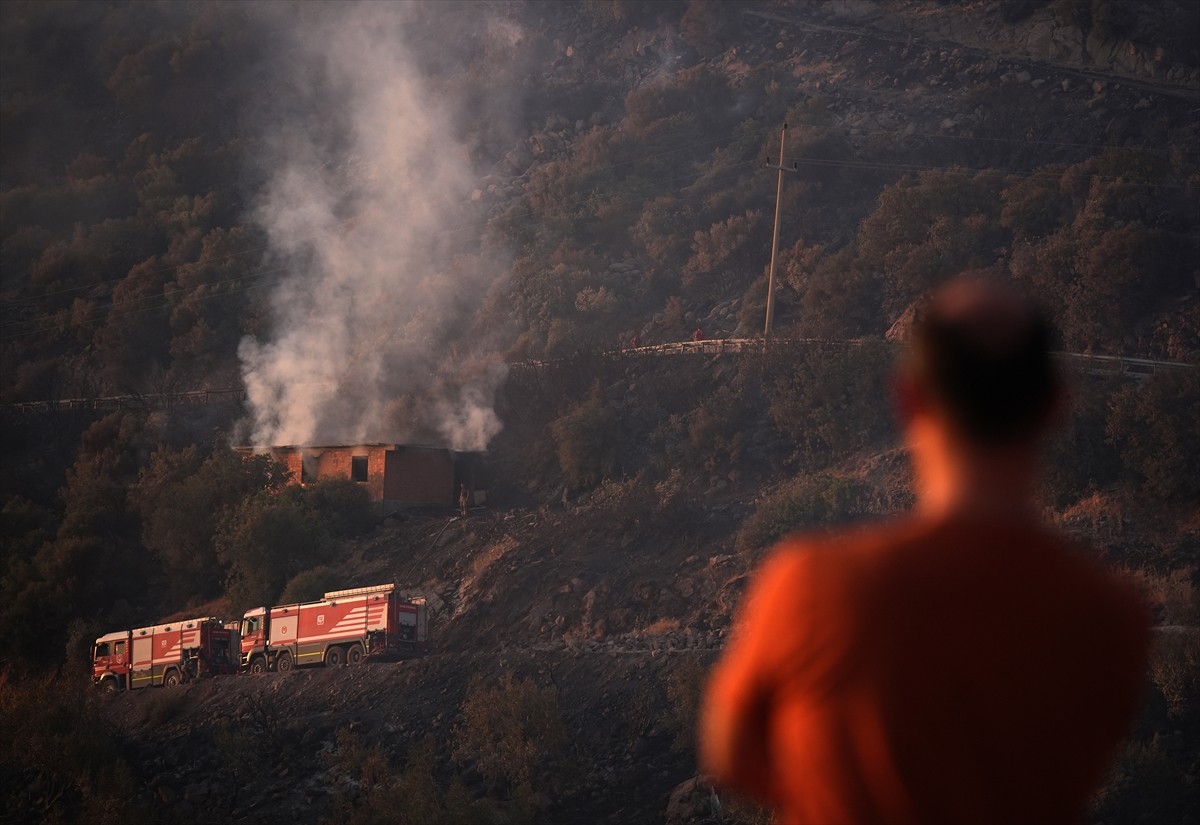 İzmir'in Dikili ilçesinde ormanlık alanda başlayan ve yerleşim yerlerine yaklaşan yangına havadan...