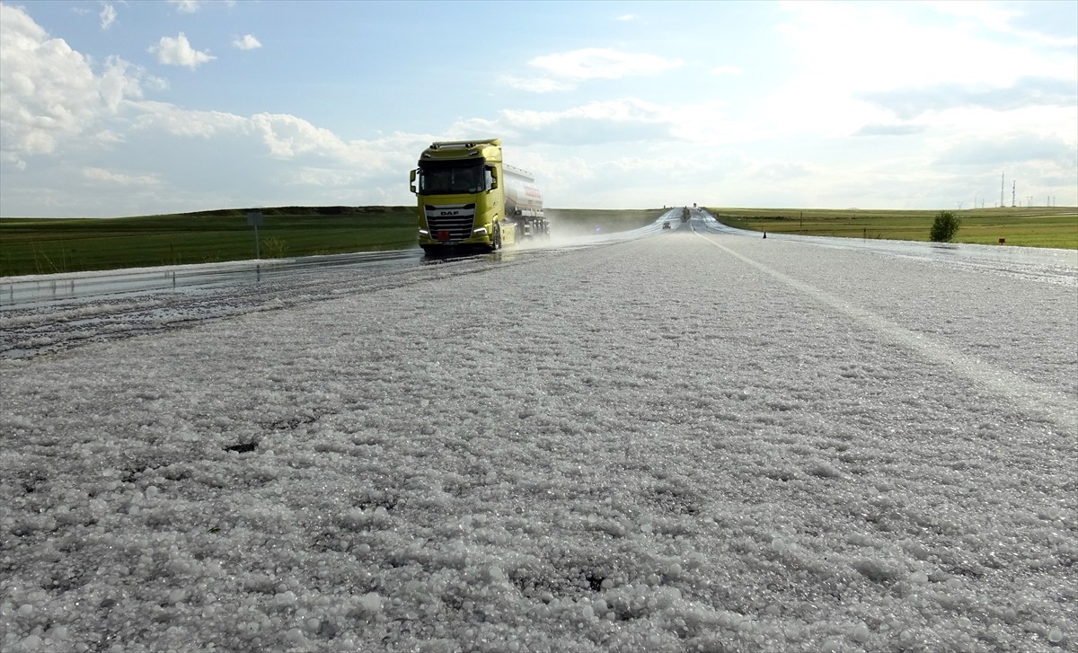 Kars'ta sağanak sonrası yağan dolu, kara yolunu ve evlerin bahçelerini beyaz örtüyle kapladı.