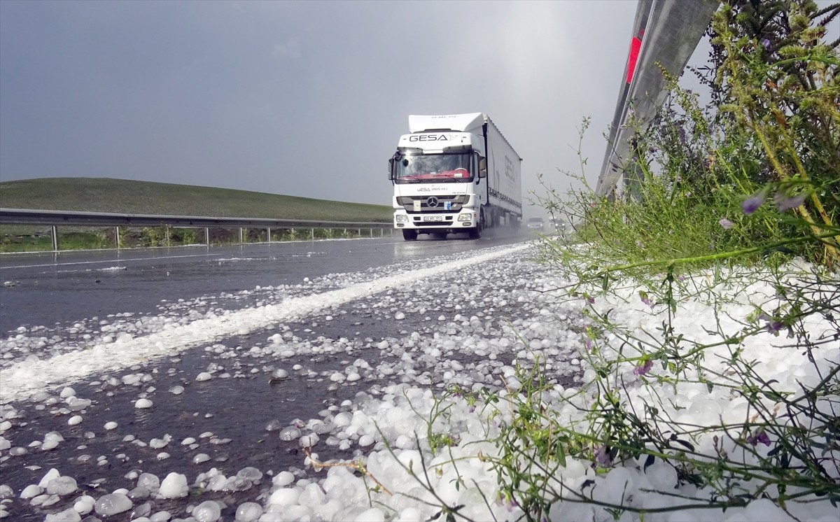 Kars'ta sağanak sonrası yağan dolu, kara yolunu ve evlerin bahçelerini beyaz örtüyle kapladı.