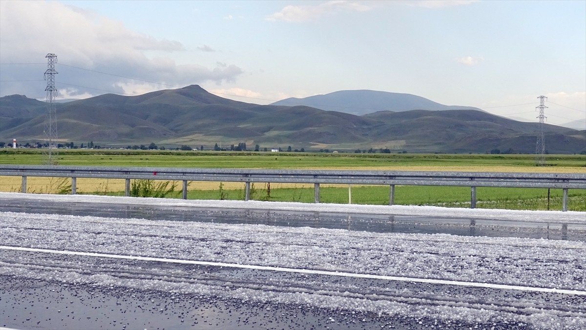Kars'ta sağanak sonrası yağan dolu, kara yolunu ve evlerin bahçelerini beyaz örtüyle kapladı.