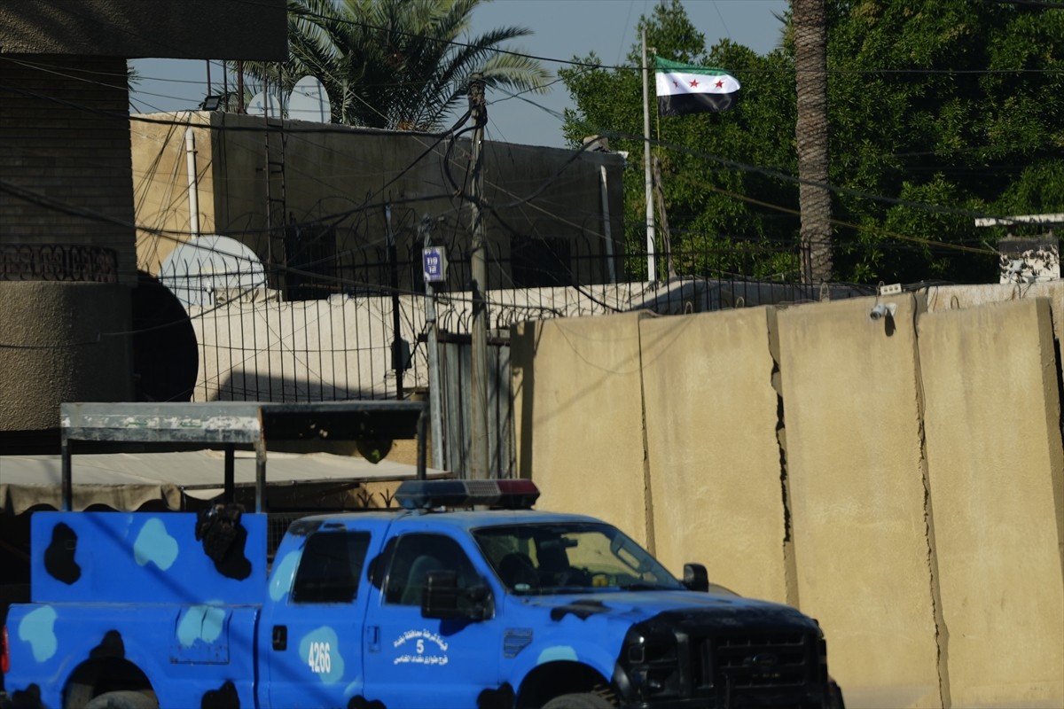 Suriye'nin Bağdat Büyükelçiliğinde, çöken Baas rejimine ait bayrağın yerine "Suriye devrimi...