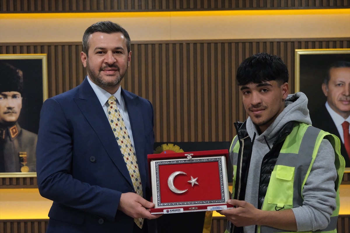 Karabük'te temizlik işçisinin, çöpten bulduğu Türk bayrağını yerden alarak bahçe duvarına asması...