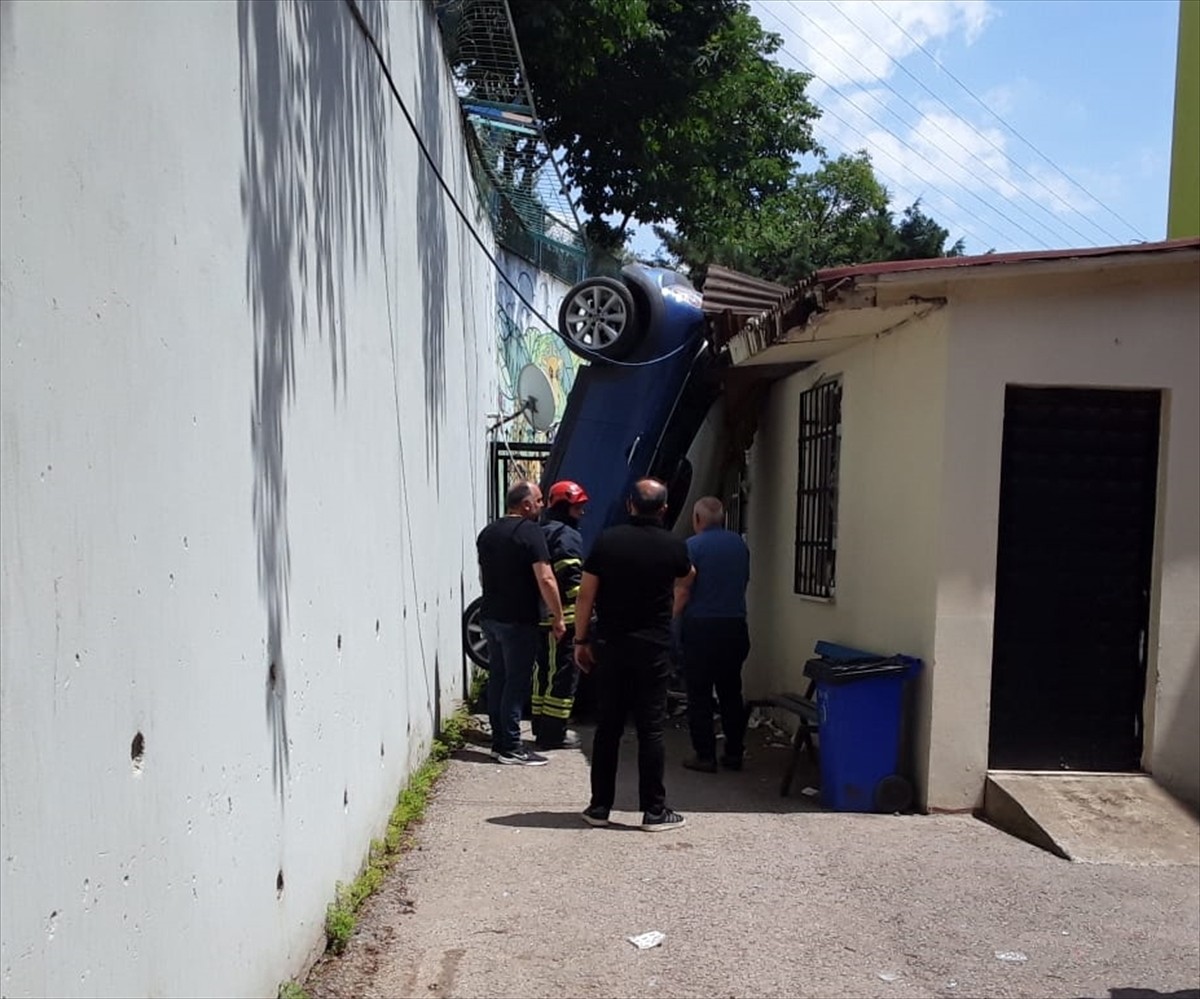 Kocaeli'nin Darıca ilçesinde istinat duvarından okul bahçesine düşerek asılı kalan otomobilin...