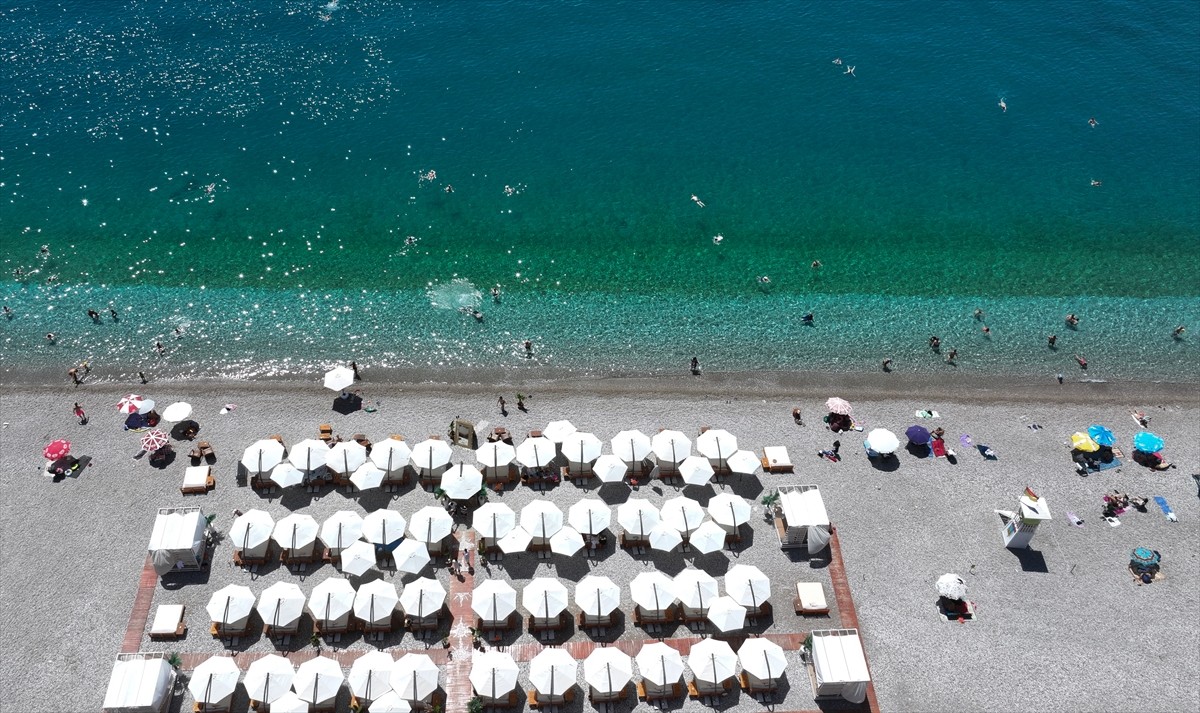 Antalya'da sıcak hava ve nemden bunalan yerli ve yabancı turistler, sahillerde ve gölgelik...