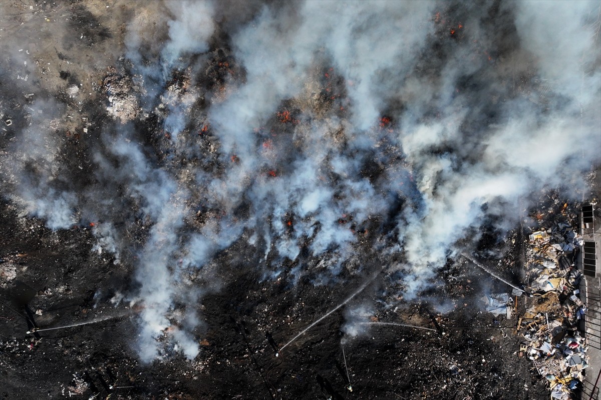 İzmir'in Buca ilçesinde boş alandaki atık yığınında çıkan yangın, itfaiye ekiplerince...