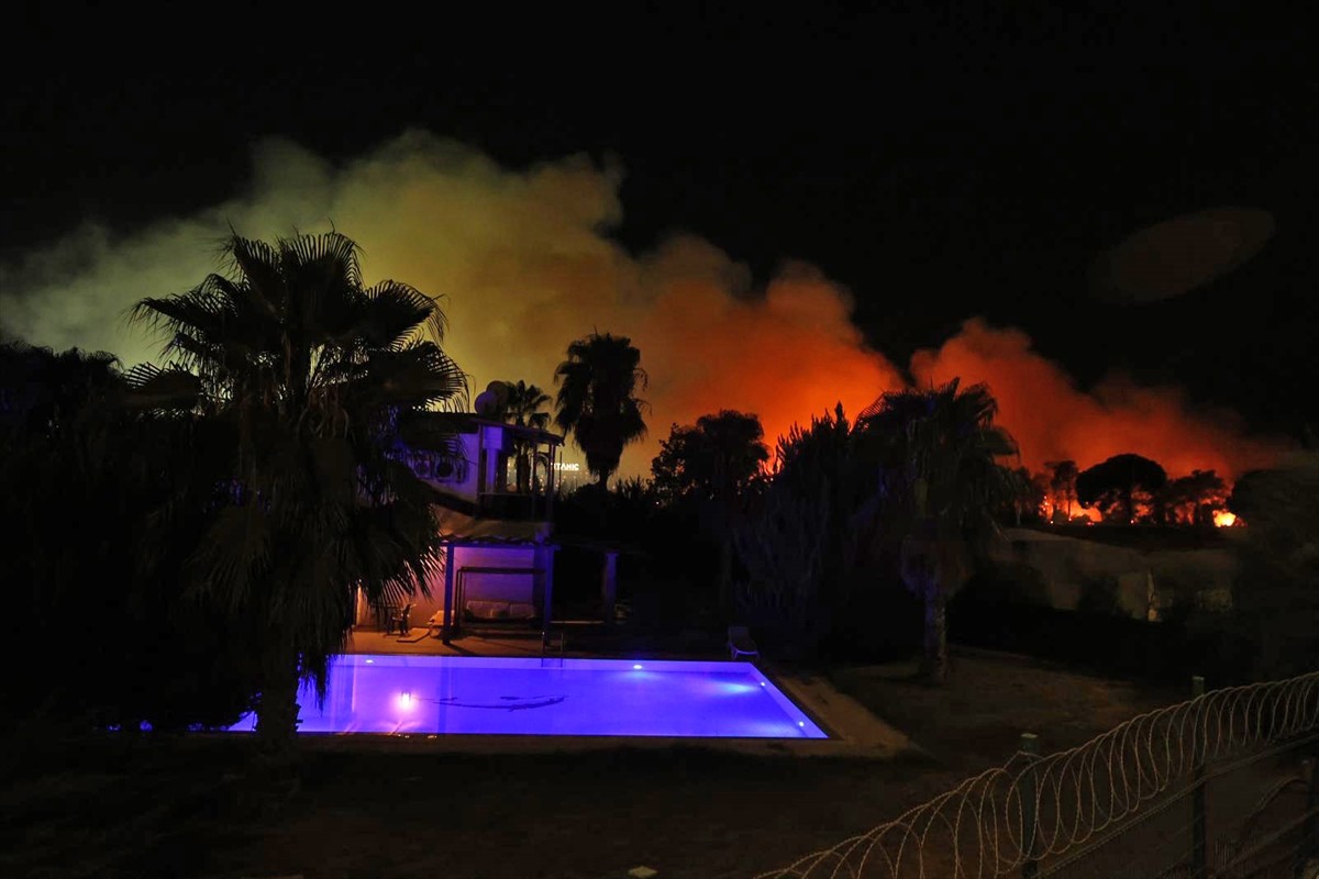  Antalya'nın Aksu ilçesinde ormanlık alanda çıkan yangına müdahale ediliyor.