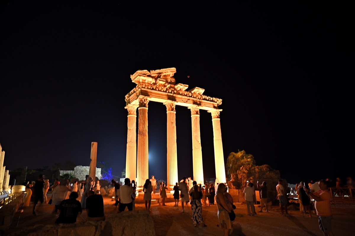 Antalya'nın Manavgat ilçesinde yerli ve yabancı turistler, Side Antik Kenti'nde kırmızı renginden...