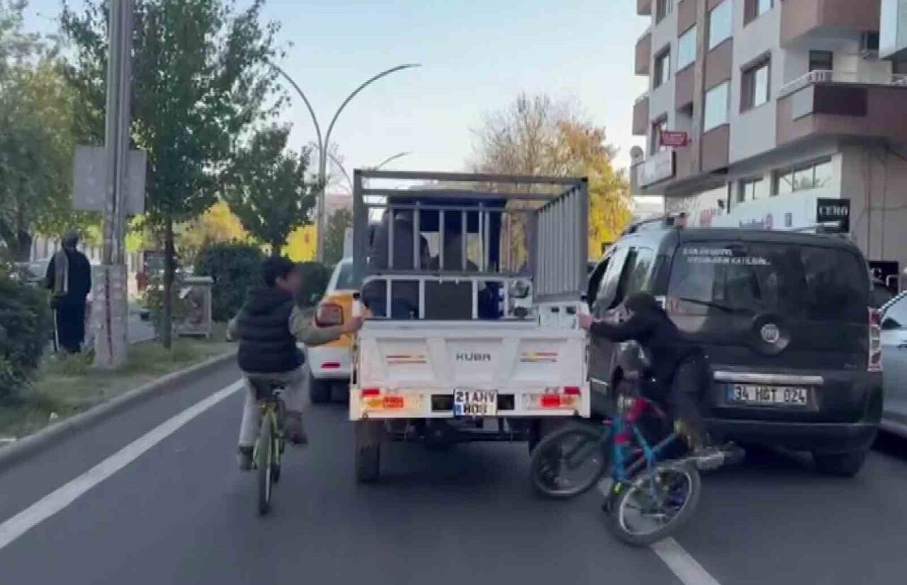 DİYARBAKIR’DA BİSİKLETLİ İKİ ÇOCUK, CANLARINI TEHLİKEYE ATARAK SEPETLİ MOTORA TUTUNUP İLERLEDİ....