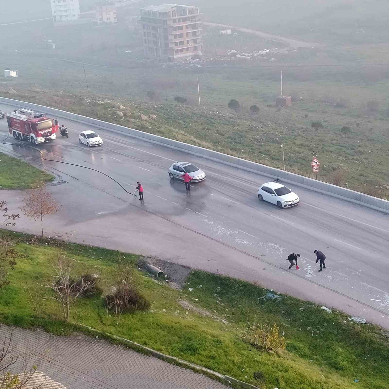 2 İTFAİYE ARACI YOLA SAÇILAN CAMLARI TAZYİKLİ SU İLE YOLUN DIŞINA ATTI.