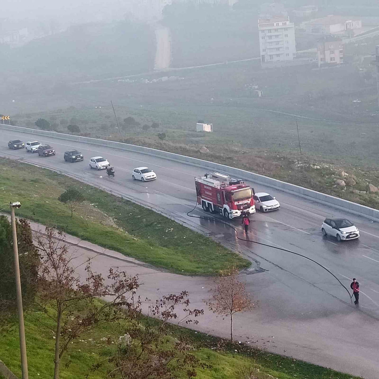 2 İTFAİYE ARACI YOLA SAÇILAN CAMLARI TAZYİKLİ SU İLE YOLUN DIŞINA ATTI.