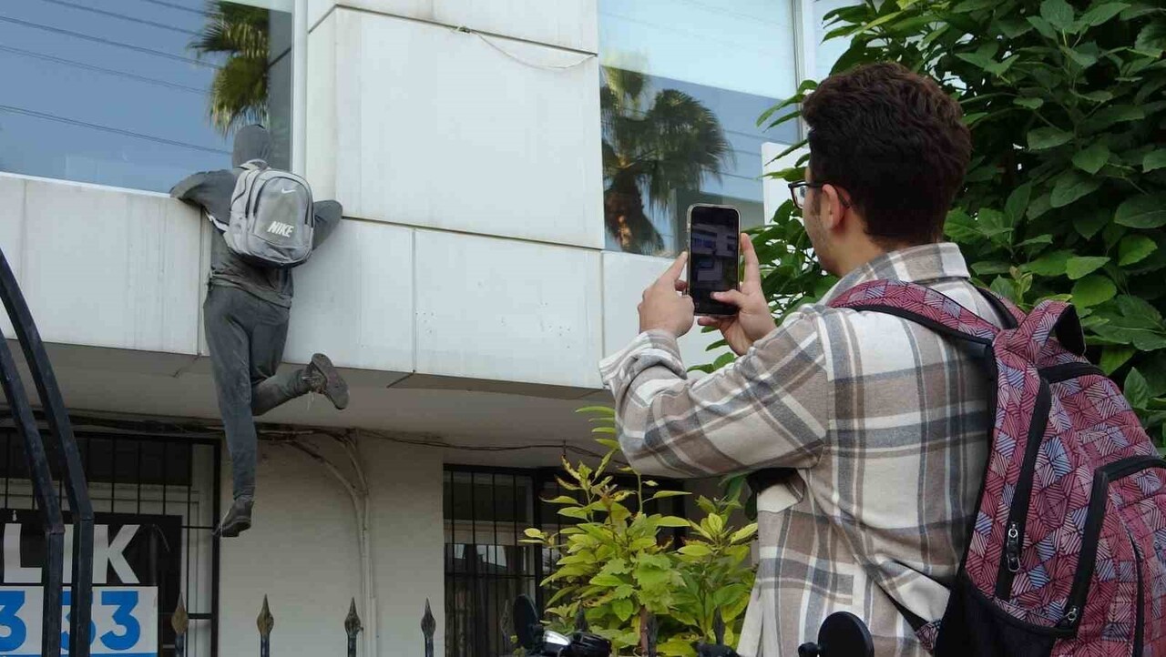 İNSANLAR, HIRSIZ GÖRÜNÜMLÜ CANSIZ MANKENİNİN FOTOĞRAFINI ÇEKİYOR