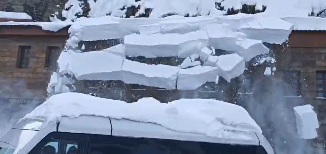 BİTLİS’TE BİR BİNANIN ÇATISINDA BİRİKEN TONLARCA AĞIRLIKTAKİ KAR KÜTLESİNİN İŞ MAKİNESİNİN ÜZERİNE...