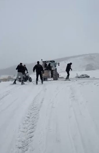GENÇLER TRAKTÖRÜN ARKASINA BAĞLADIKLARI KAYAKLA KAYARAK KARIN KEYFİNİ ÇIKARTILAR.